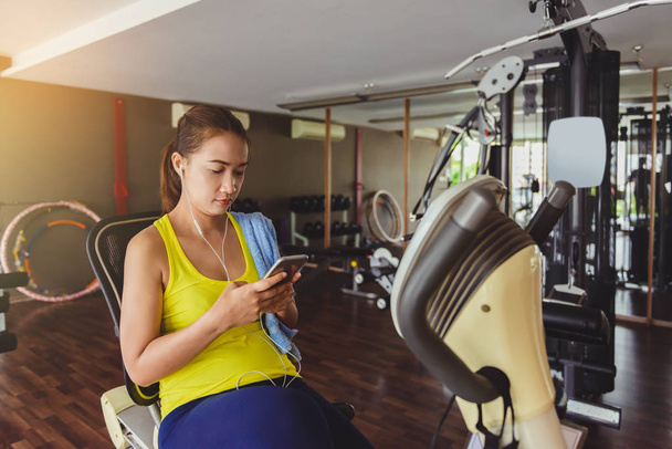 women using smartphone in fitness gym - Foto, Imagem