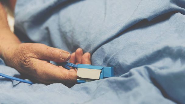 Patient in the hospital with pulse gauge on finger - 写真・画像