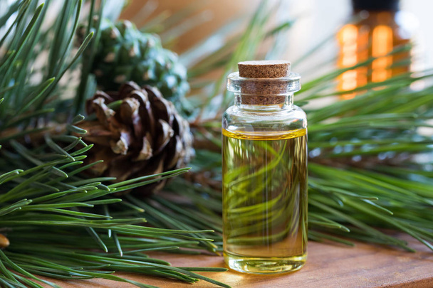 A bottle of pine essential oil with pine twigs - Photo, Image