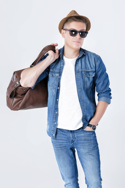 man in hat and sunglasses carrying leather bag on shoulder - Foto, Imagem
