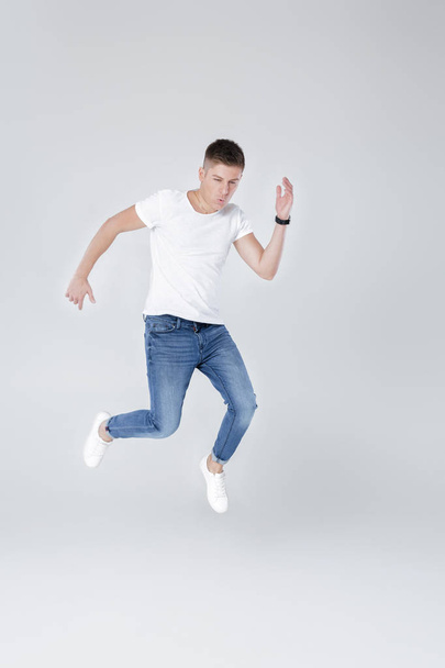 handsome man in jeans and jacket jumping - Foto, Bild