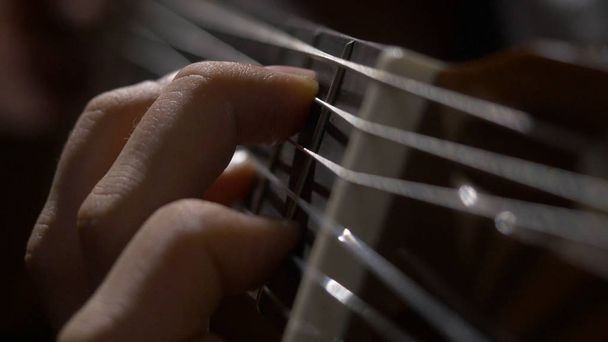 Gros plan du guitariste jouant de la guitare acoustique à la main. Gros plan d'un homme avec ses doigts sur les frets d'une guitare jouant
 - Photo, image
