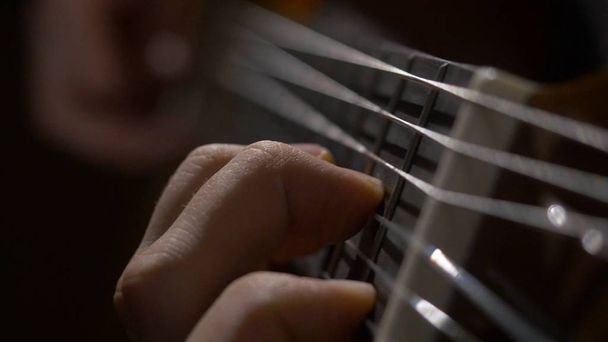 Primer plano del guitarrista tocando la guitarra acústica. Primer plano de un hombre con los dedos en los trastes de una guitarra tocando
 - Foto, Imagen