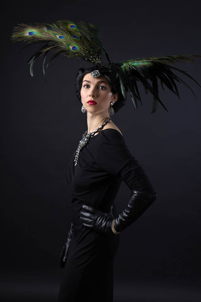 Woman in retro style with feather headdress. - 写真・画像