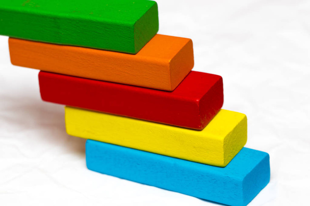 ladder made from colorful wooden blocks on a white background. T - Photo, Image