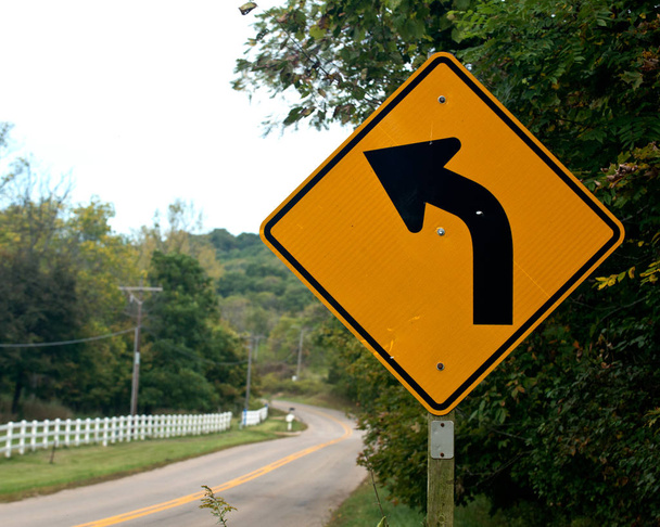 黄色の道路標識を示す左折 - 写真・画像