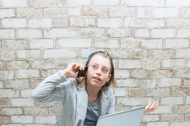 Teen κορίτσι μιλάει στο τηλέφωνο στο φόντο τοίχο - Φωτογραφία, εικόνα
