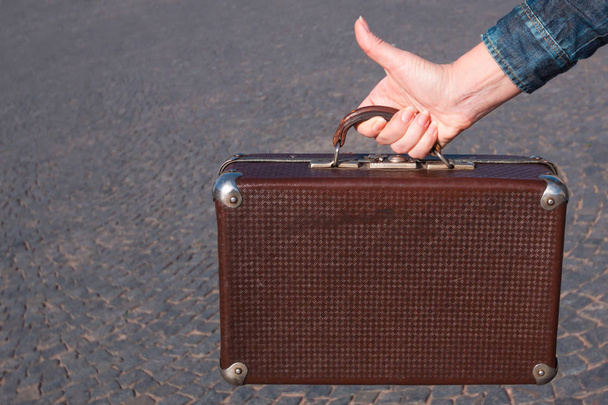 vintage suitcase of the 30s suitcase in woman hand on the backgr - 写真・画像