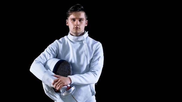 Portrait Shot of a Young Fencer Standing and Looking into Camera. Shot Isolated on Black Background. - Foto, afbeelding