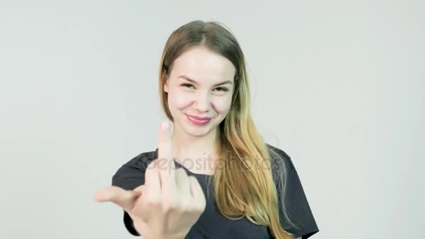 Belleza mujer mostrando el dedo medio y sonriendo sobre fondo blanco
 - Metraje, vídeo