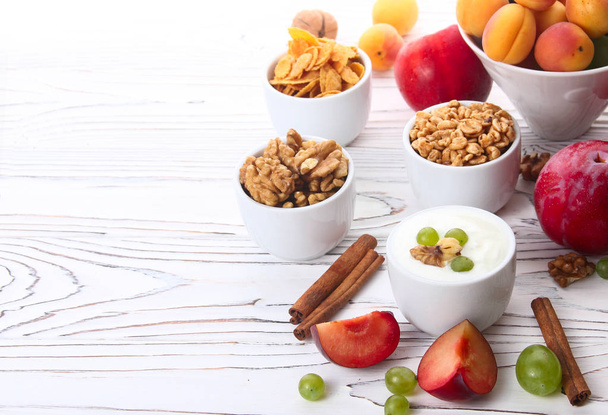 Granola, muesli, nuts, yogurt and fresh fruit - Фото, изображение