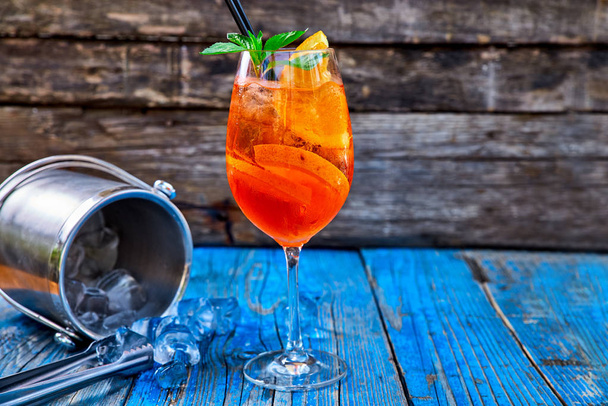 Spritz Aperol cocktail in wine glass on rustic wooden background - Photo, image