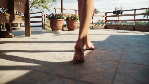 Kaunis nuori tyttö paljain jaloin liikkuvat ulkona
 - Materiaali, video