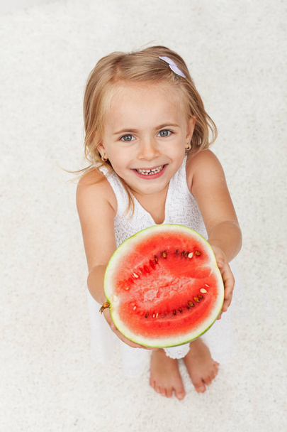 Menina feliz dando-lhe metade de uma melancia
 - Foto, Imagem