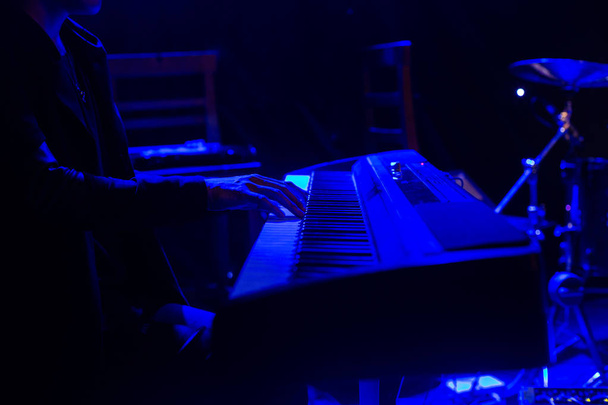 Homme jouant sur le clavier du synthétiseur sur scène pendant le concert
 - Photo, image