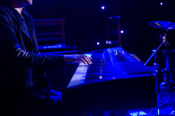 Muž si hraje na syntezátor klávesnice na pódiu při koncertu - Fotografie, Obrázek