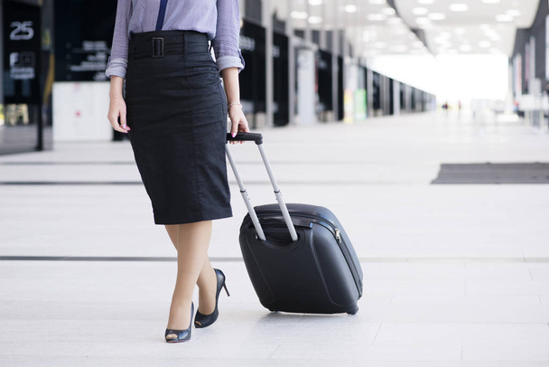 Business woman walking with wheeled bag - Foto, imagen