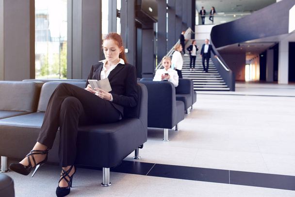 Businesswoman with phone in lobby - Photo, image