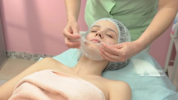 Cosmetician applying facial collagen mask. - Footage, Video