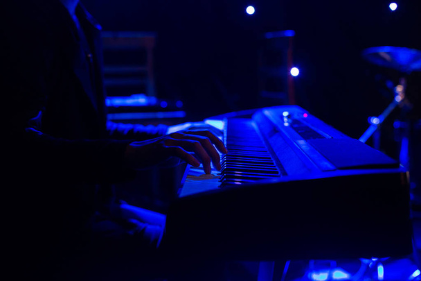 Ο άνθρωπος που παίζει στο πληκτρολόγιο συνθεσάιζερ στη σκηνή κατά τη διάρκεια συναυλίας - Φωτογραφία, εικόνα