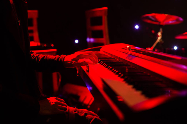Hombre tocando en el teclado sintetizador en el escenario durante el concierto
 - Foto, Imagen