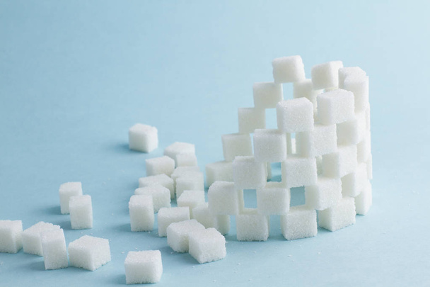 Tower of cubes of sugar on blue - 写真・画像