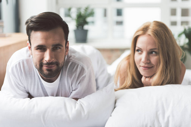 Joyful young man and woman relaxing in bedroom - Photo, Image