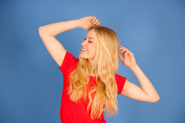 beautiful young blond teenage woman in vibrant t shirt dance iso - 写真・画像