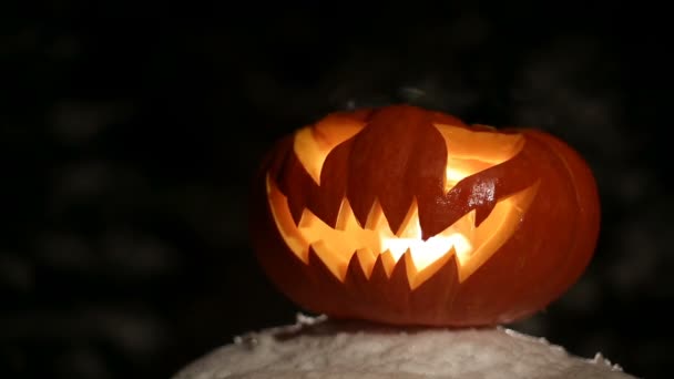 Oyma Halloween balkabağı ışıklar içinde alev siyah bir arka plan ile yakın çekim - Video, Çekim