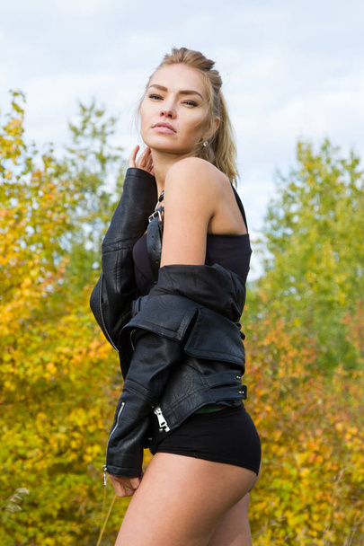 Fille en veste en cuir noir et lingerie sur fond de forêt d'automne
 - Photo, image