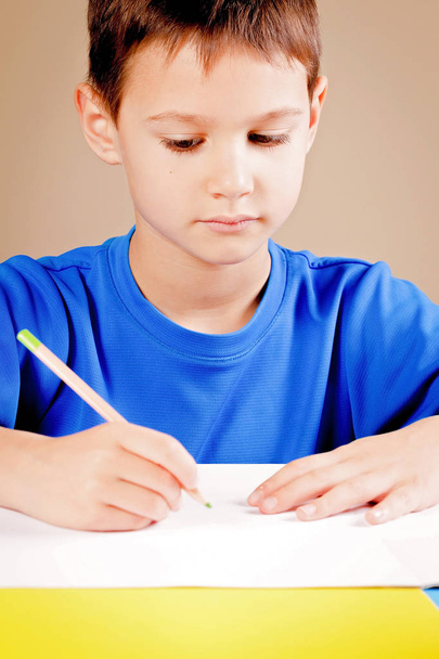 Little boy drawing with colored pencils - Fotó, kép