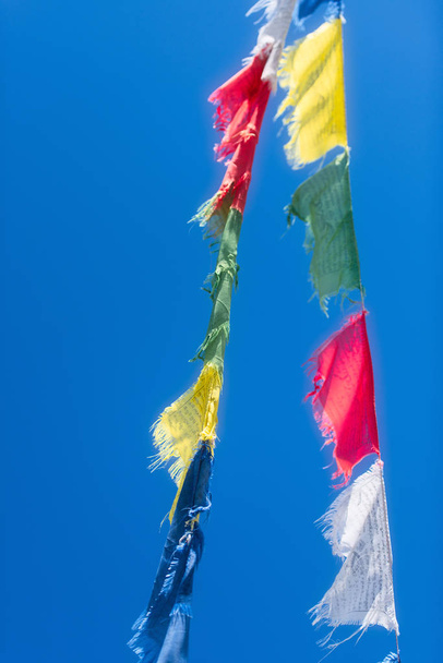 Vertical rows of colorful Tibetan Buddhist prayer flags waving i - Photo, Image