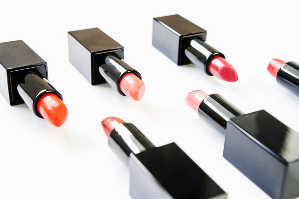 Multi colored lipstick arranged in rows on a white background. - Фото, изображение