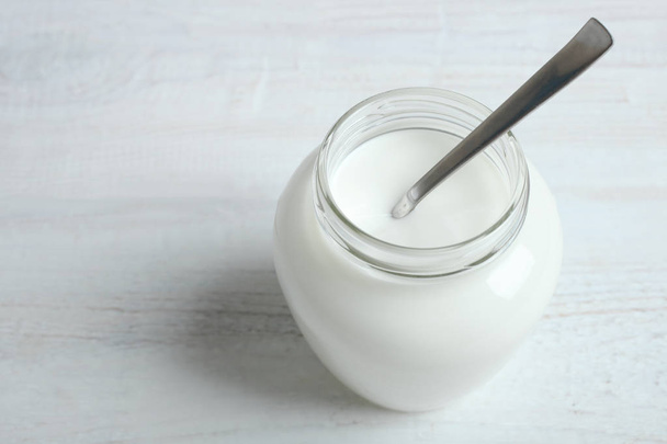 A jar with a yogurt and a spoon  - Photo, Image