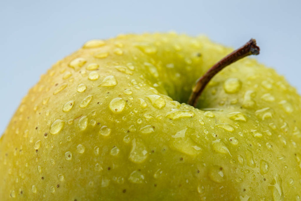 Macro de manzana amarilla cubierto con gotas de agua
 - Foto, imagen