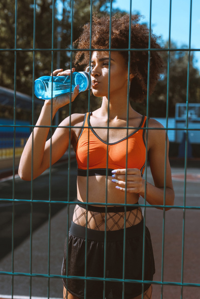 fit african-american woman drinking water - 写真・画像