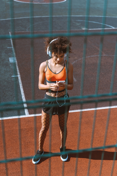 Αφρικανικός-αμερικανική γυναίκα να ακούτε μουσική στα ακουστικά  - Φωτογραφία, εικόνα