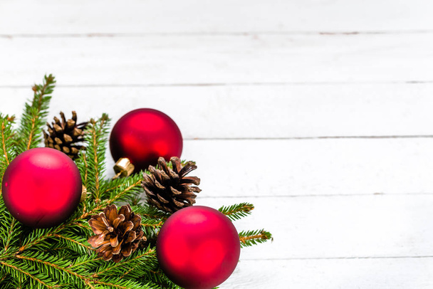 Weihnachten Hintergrund mit roten Ornamenten und grünen Tannenzweigen auf Holzbrettern - Foto, Bild