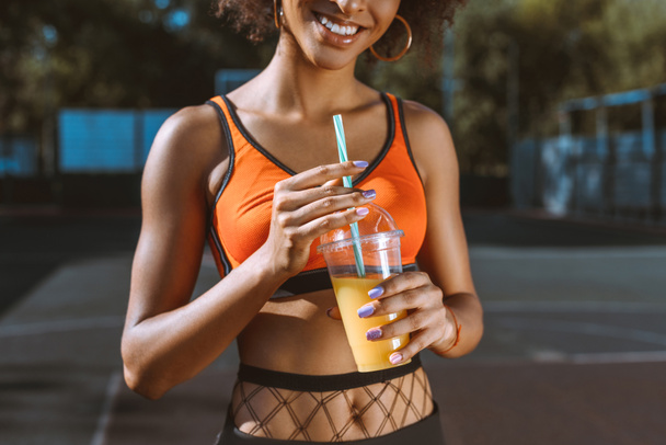 atlética afroamericana mujer bebiendo jugo
 - Foto, imagen
