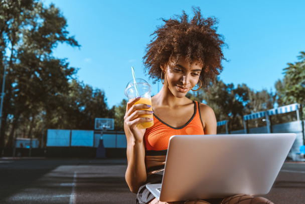 donna afro-americana con laptop e succo di frutta
 - Foto, immagini