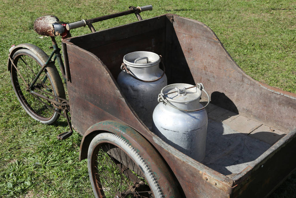 повозка со старым велосипедом для транспортировки молока, только что заквашенного из т
 - Фото, изображение