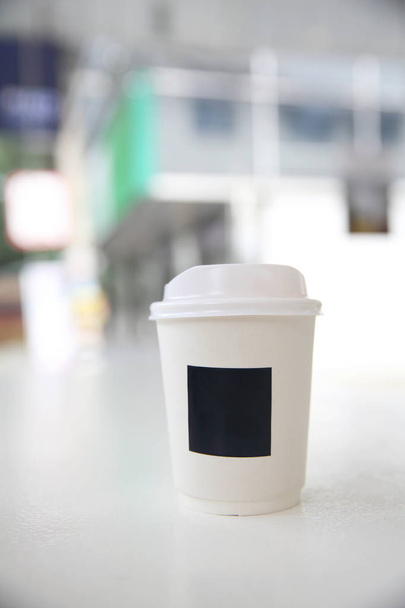 Caffè cappuccino in tazza di carta da caffè in caffè bianco
 - Foto, immagini