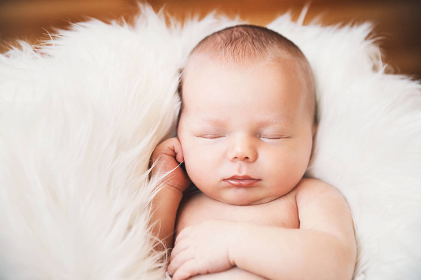 Sleeping newborn baby in a wrap on white blanket. - Photo, Image