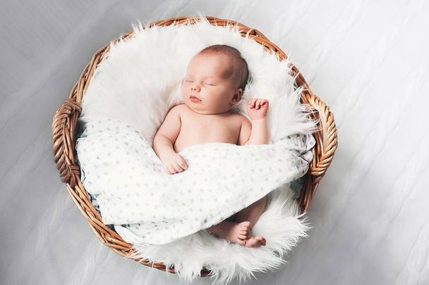 Sleeping newborn baby in a wrap on white blanket. - Photo, image