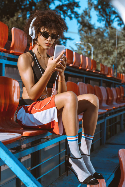 Athletic african-american woman in headphones - Zdjęcie, obraz