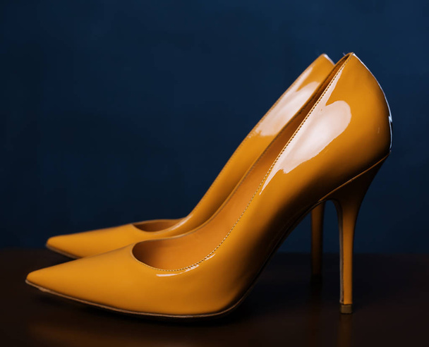 Żółty kobiece buty na ciemnej powierzchni drewnianych. Letnie buty damsk - Zdjęcie, obraz
