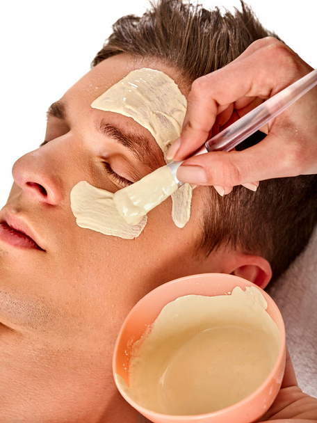 Mud facial mask of man in spa salon. Face massage . - Photo, Image