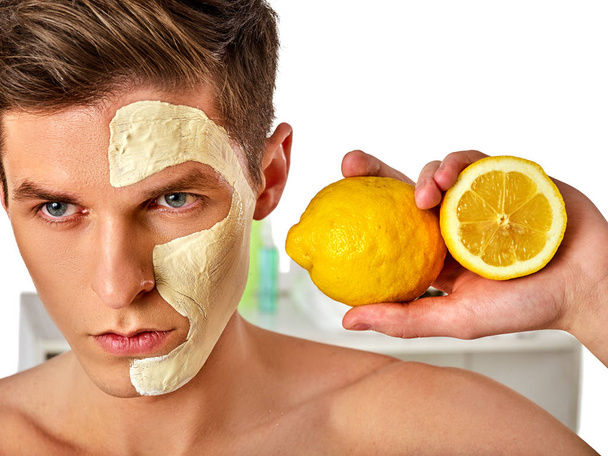 Ο άνθρωπος του προσώπου μάσκα από φρούτα και πηλό. Πρόσωπο λάσπη εφαρμόζεται. - Φωτογραφία, εικόνα