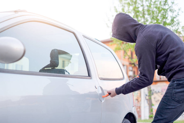 Ladrón tratando de abrir la cerradura del coche estacionado
 - Foto, Imagen