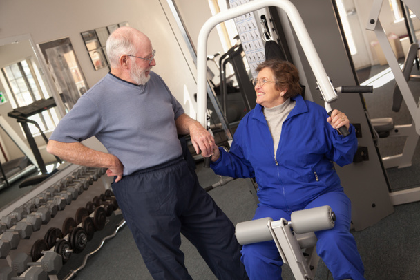 Pareja de adultos mayores haciendo ejercicio juntos en el gimnasio
 - Foto, Imagen